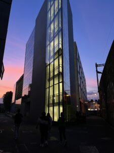 Photo of a building in Dublin during sunset. Blue skies on top fade into orange and pink.